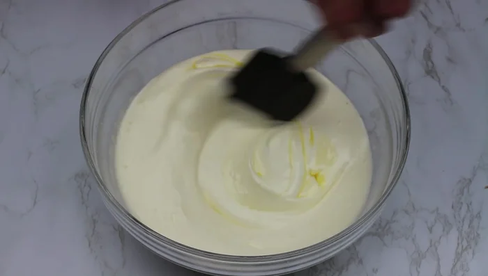 Ajouter le beurre fondu et refroidi, la levure chimique et la farine tamisée. Mélanger délicatement à la spatule.