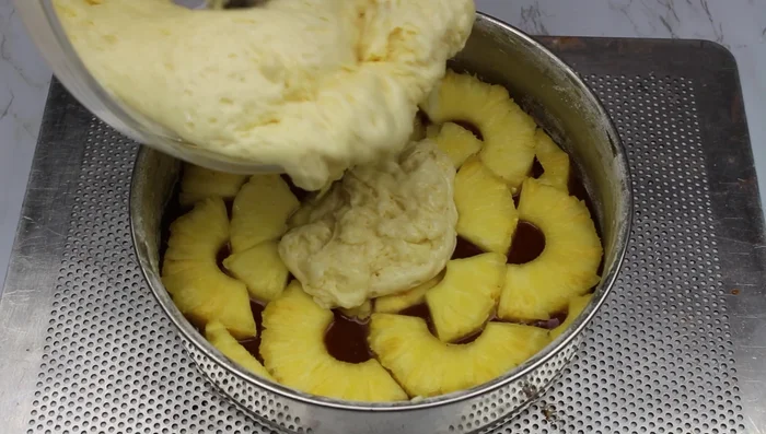 Verser la pâte sur les ananas.
