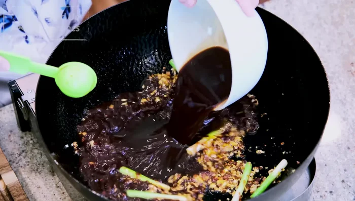 Ajouter la sauce : Verser la sauce dans la marmite et remuer jusqu'à épaississement.
