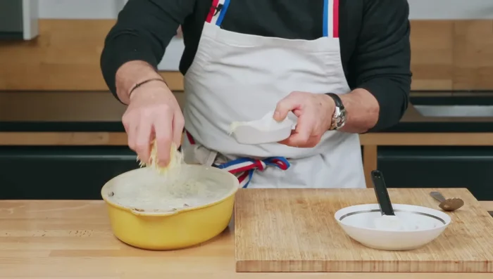Ajouter du gruyère râpé et répartir la béchamelle uniformément. [293.88]