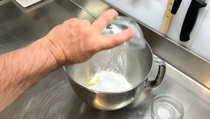 Préparation de la pâte sucrée : Crémer le beurre, le sucre glace et le sel. Ajouter la poudre d'amande, puis l'œuf et enfin la farine. Former une boule, aplatir et réfrigérer.