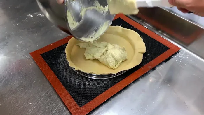 Étaler la crème amande pistache sur le fond de tarte.