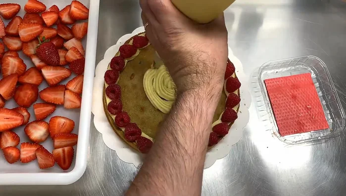Étaler une couche de crème pâtissière, puis disposer les fraises.