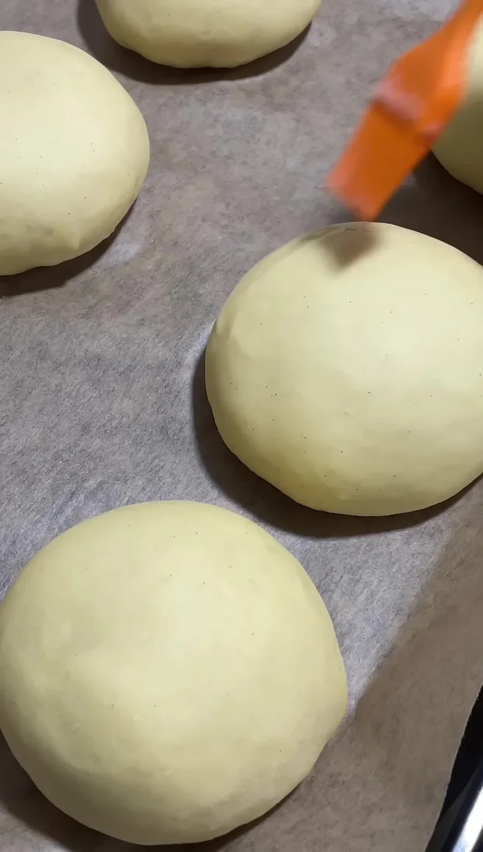Badigeonnez les pains avec la dorure. Saupoudrez de graines de sésame (facultatif).