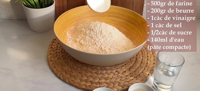 Préparer la pâte feuilletée : mélanger la farine, le sel et le sucre. Râper le beurre congelé et l'incorporer au mélange sec.