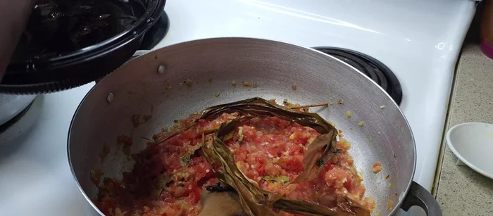 Ajouter les tomates, les feuilles de gingembre et les feuilles d'oignon. Bien mélanger et laisser cuire 5 minutes.
