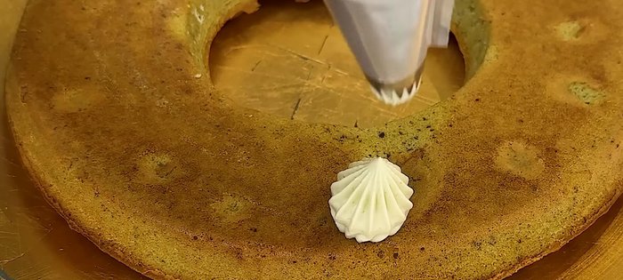 Décorer le gâteau avec la ganache à l'aide d'une poche à douille et de différentes douilles.