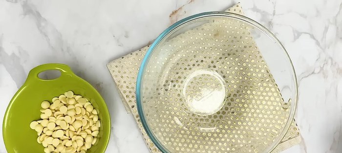 Préparer la ganache : faire chauffer la crème et la verser sur le chocolat blanc et la pâte de pistache fondus.