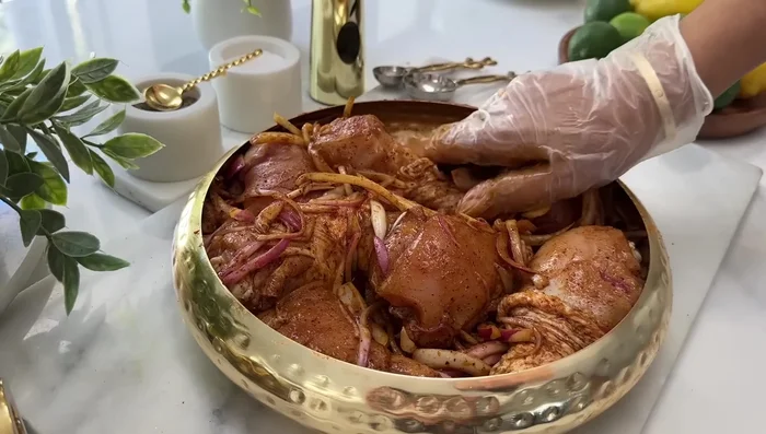 Parsemer quelques oignons sur le dessus du poulet, couvrir avec du papier sulfurisé puis du papier aluminium et enfourner à 200° pendant environ 45 minutes.