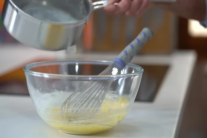 Tempérer les jaunes d'œufs avec le lait chaud. Verser le mélange dans une casserole et cuire à feu moyen en fouettant continuellement jusqu'à épaississement.