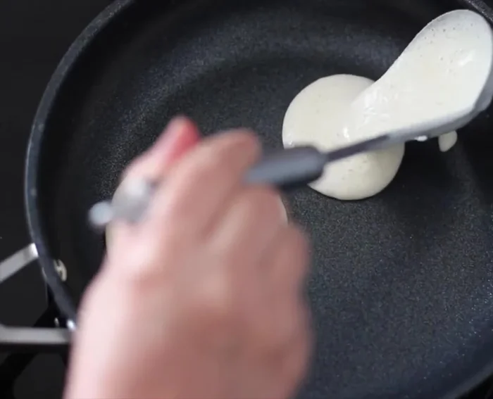 Cuire les mini-crêpes dans une poêle antiadhésive à feu moyen, sur un seul côté, jusqu'à ce qu'elles soient sèches en surface. Les déposer sur un torchon propre pour les laisser refroidir.