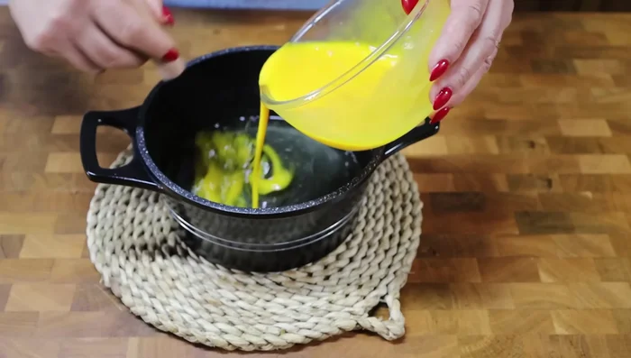 Incorporer progressivement le sirop de sucre au mélange œufs, en remuant délicatement pour éviter de cuire les œufs.