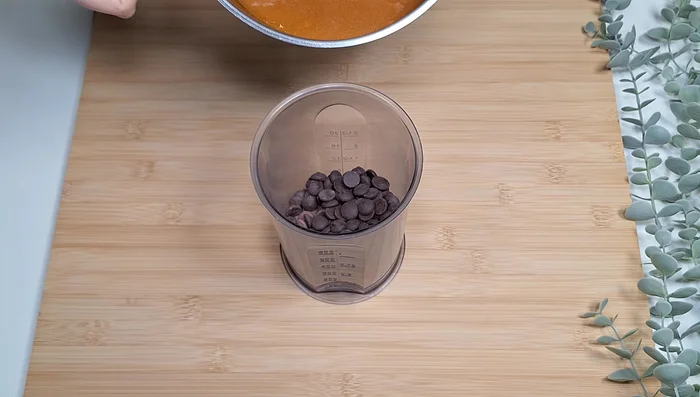 Faites fondre le chocolat au lait et noir. Versez le caramel bouillant dessus et mixez au mixeur plongeant jusqu'à obtenir une ganache homogène (233.36).
