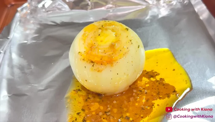 Placez les oignons sur une plaque à pâtisserie recouverte de papier d'aluminium. Versez la sauce sur les oignons, assaisonnez (Old Bay, poivre citronné, paprika) et enveloppez-les dans du papier aluminium.
