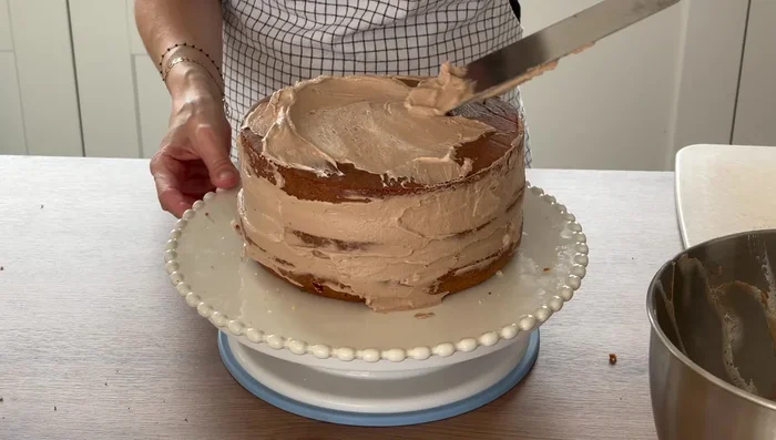 Recouvrir le gâteau de crème, lisser grossièrement et réfrigérer toute une nuit.