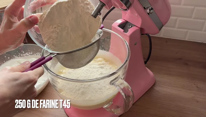 Ajouter la farine tamisée et la levure chimique au mélange sucre/œufs. Mélanger délicatement avec la feuille du robot.