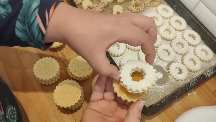 Pour l'assemblage : Étaler une fine couche de confiture sur la moitié des sablés. Recouvrir avec les autres sablés pour former des sandwichs. Décorer avec du sucre glace, des amandes concassées, etc.