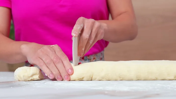 Diviser la pâte en 10 parts égales (environ 68-70g chacune). Former des boules, les couvrir et laisser reposer 10 minutes.