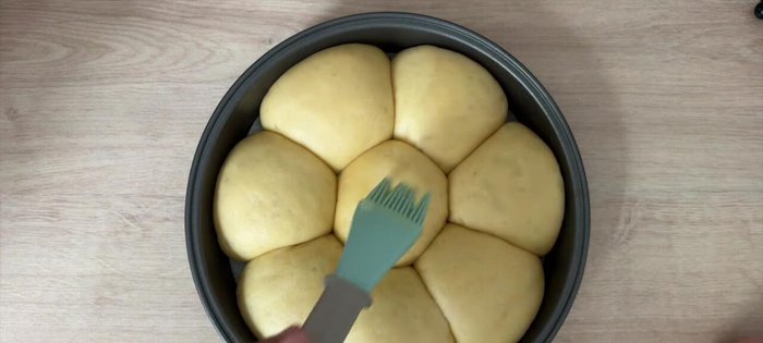 Badigeonnez la brioche d'un mélange de lait et d'œuf, saupoudrez de sucre en grain.