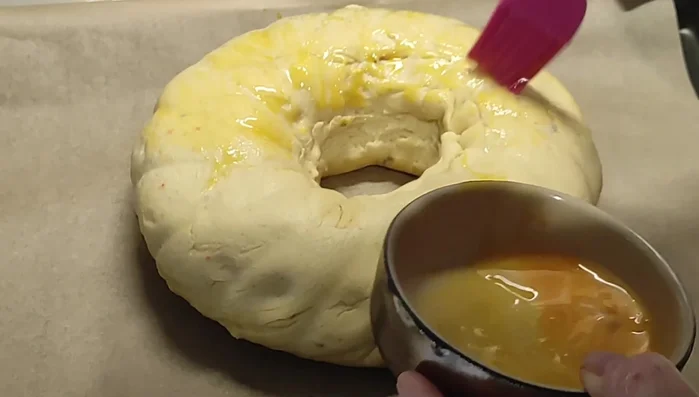 Le lendemain, préchauffer le four à 160°C. Dorer la brioche avec un jaune d'œuf et ajouter du sucre perlé. Faire des petites incisions sur la surface.