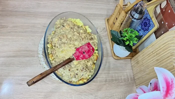 Dans un plat allant au four (Pyrex), disposez une couche de pommes de terre, puis la sauce au poulet et aux oignons. Répétez l'opération avec une autre couche de pommes de terre, la sauce et terminez par une couche de fromage.