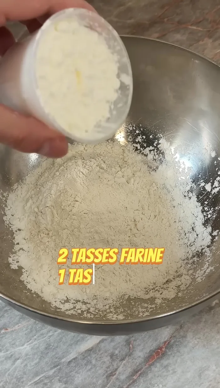 Ajoutez 1 tasse et demie d'eau en deux fois, en mélangeant bien jusqu'à obtenir une pâte homogène.
