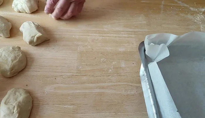 Préparer un moule à four recouvert de papier cuisson. Former des boules avec les morceaux de pâte et les placer dans le moule.