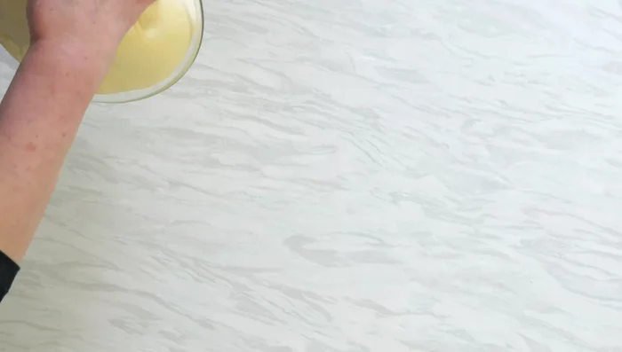 Versez la pâte sur une planche à pâtisserie légèrement huilée.