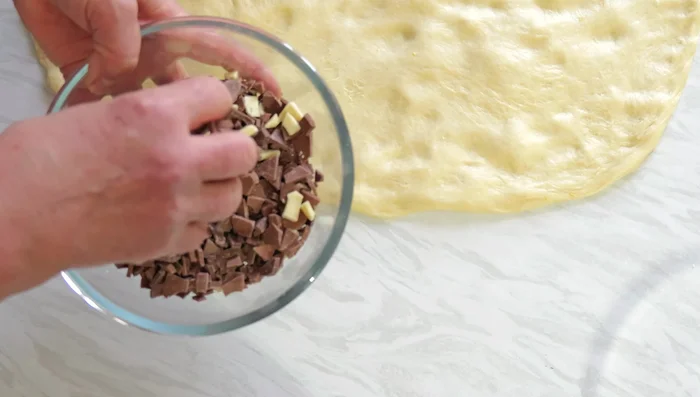 Coupez des morceaux de chocolat et des œufs de Pâques et répartissez-les sur la pâte.