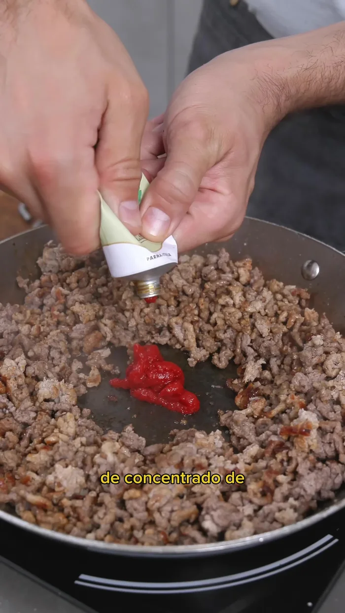 Assaisonner la viande avec du sel, du poivre, de la pâte de tomate, faire frire et ajouter du vin blanc et du bouillon. Réduire jusqu'à évaporation complète.