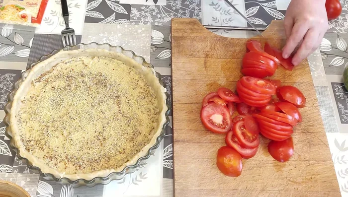 Couper les tomates et les répartir sur la pâte recouverte de moutarde et de semoule.