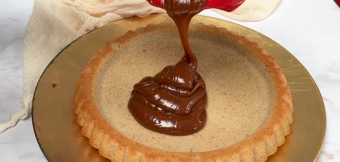 Verser la ganache spéculoos sur le fond de gâteau et lisser avec une spatule.