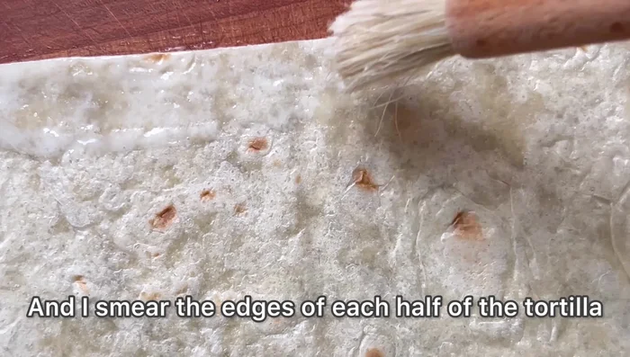 Badigeonnez les bords des moitiés de tortillas avec la colle, pliez en triangle et appuyez légèrement (104.799)