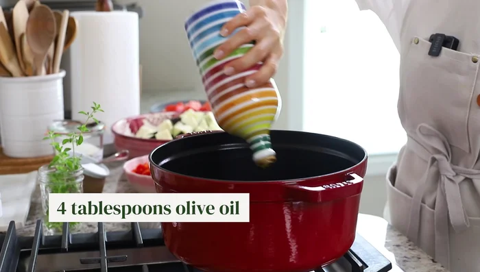 Faire chauffer 4 cuillères à soupe d'huile d'olive dans un grand faitout. Ajouter l'oignon haché et les poivrons. Faire sauter jusqu'à tendreté (8-10 minutes).