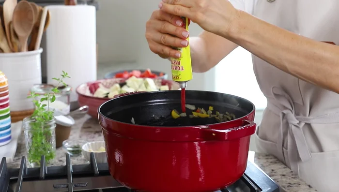 Ajouter le concentré de tomates, l'ail émincé. Cuire 1 minute.