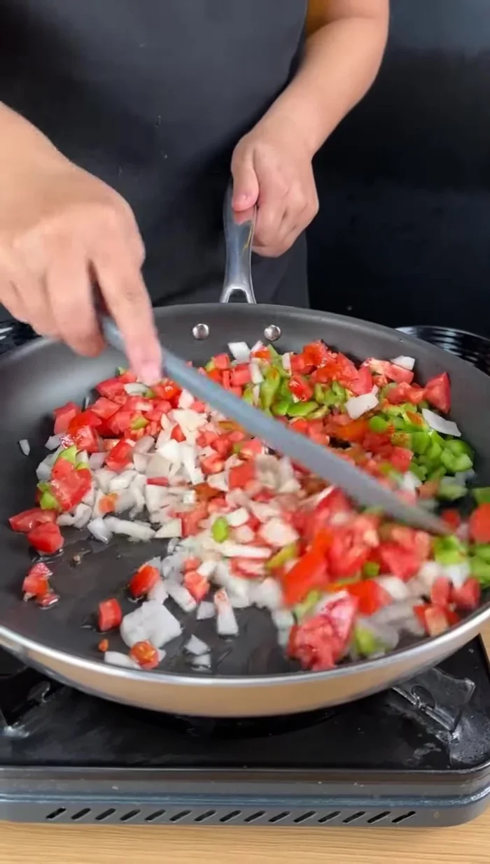 Ajoutez une cuillère à café de paprika doux et faites revenir le tout jusqu'à ce que les ingrédients soient tendres et dorés.