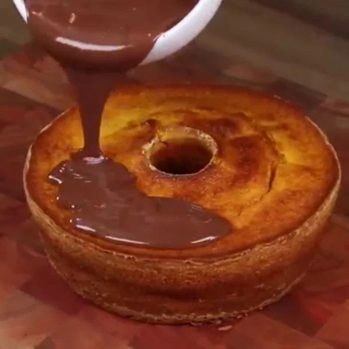 Verser le mélange chocolat-crème fraîche sur le gâteau refroidi.