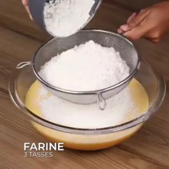 Ajouter trois tasses de farine de blé tamisée et bien mélanger.