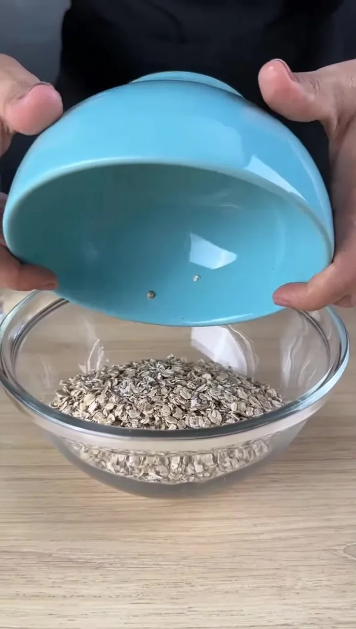 Mettez une tasse de flocons d'avoine dans un récipient et ajoutez de l'eau jusqu'à ce qu'ils soient complètement recouverts. Utilisez de l'eau à température ambiante.