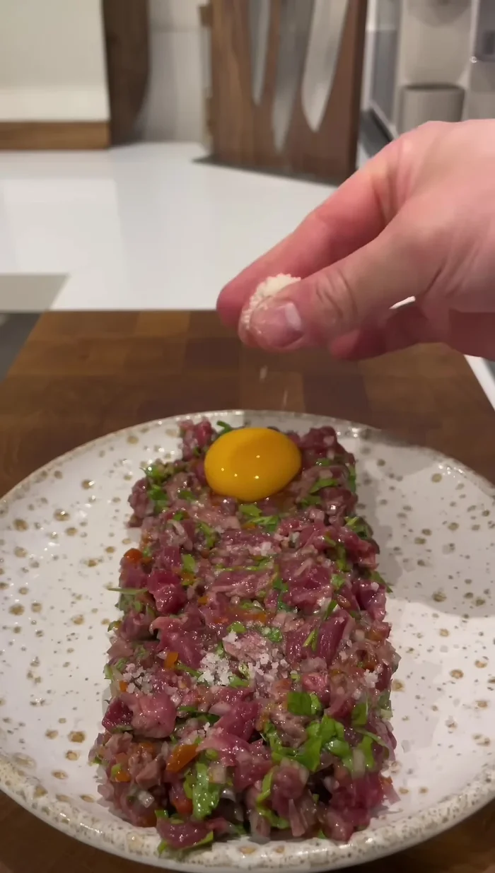 Gratiner le parmesan : parsemer du parmesan sur le jaune d'œuf, gratiner à l'aide d'un chalumeau, poivrer et saler le jaune d'œuf.