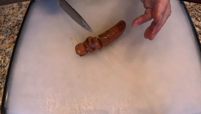 Couper la saucisse en tranches d'environ 1/4 de pouce d'épaisseur et faire sauter dans de l'huile d'olive jusqu'à ce qu'elle soit dorée.