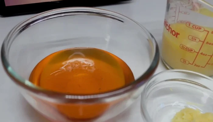 Préparer le glaçage : mélanger le miel, le bouillon de poulet, la fécule de maïs, la pâte d'ail, le gingembre, le vinaigre balsamique, l'huile d'olive, les herbes séchées (persil, thym, basilic), le piment et le paprika. Réserver.