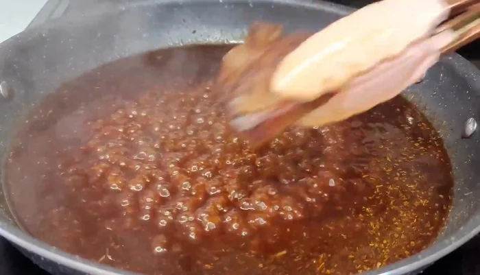 Remettre les côtelettes d'agneau dans la poêle avec le glaçage épaissi. Cuire 1 minute de chaque côté pour assurer une cuisson uniforme et un enrobage complet de la sauce.