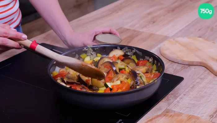 Retirer la gousse d'ail de la ratatouille et verser celle-ci dans un plat à gratin (148.36).