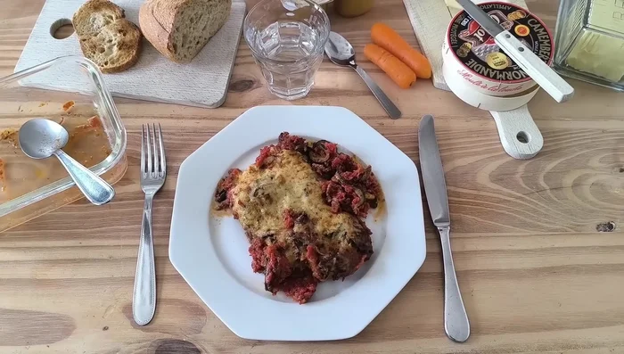Dans un plat allant au four, superposer les courgettes, les tomates, le bœuf haché, les herbes et le fromage.