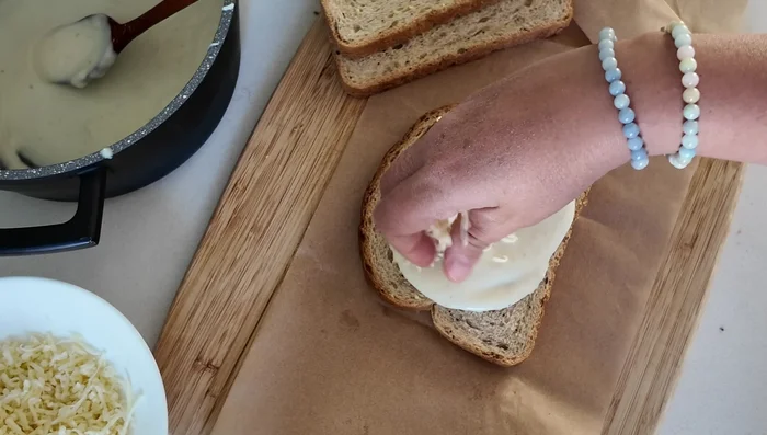 Couche 1: Béchamel, jambon de poulet, fromage râpé, pain.