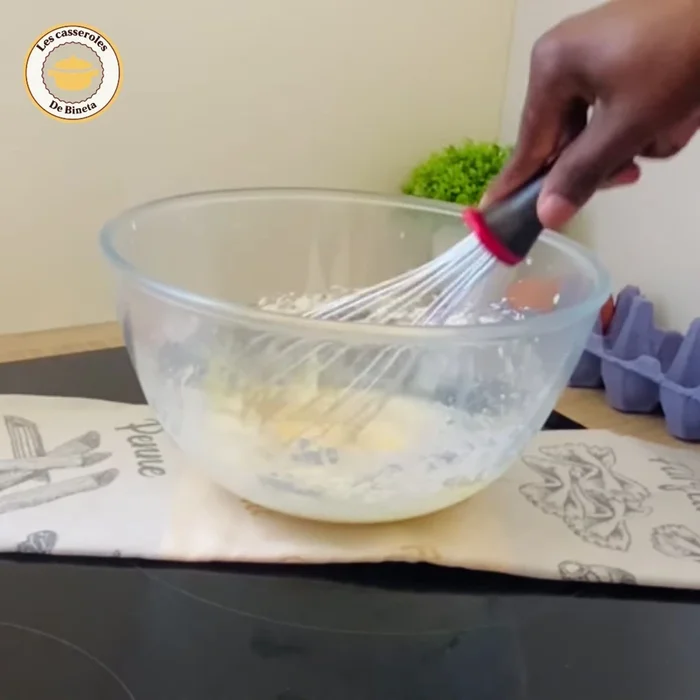 Incorporer le lait chaud en trois fois, en mélangeant bien entre chaque ajout pour éviter les grumeaux.