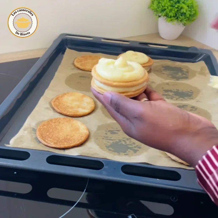 Superposer deux pâtes garnies, fermer avec une troisième pâte et lisser les bords avec de la crème.
