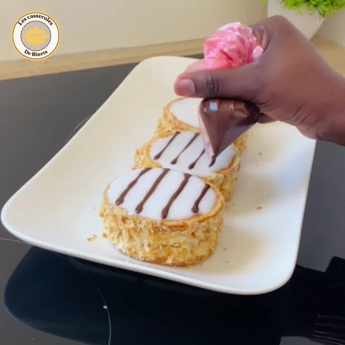 Faire fondre 25 g de chocolat noir et décorer les mille-feuilles. Mettre au frais pendant au moins 4 heures.
