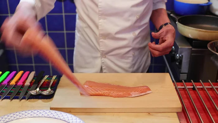 Préparation du saumon: Couper le saumon en deux, retirer la peau (conserver pour le chien) et couper la chair en morceaux.